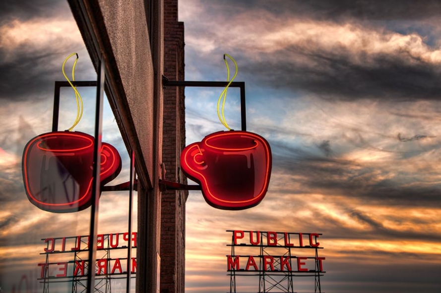 neon coffee cup sign in Seattle with sunset sky behind