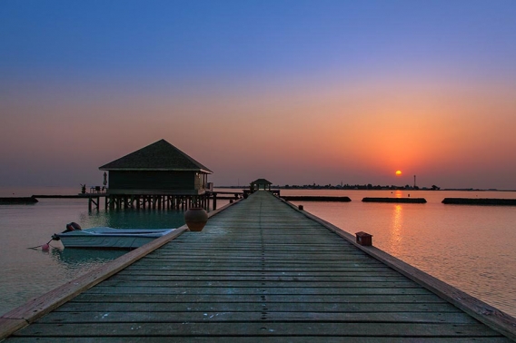 jetty at sunset on the island of komandoo in the maldives